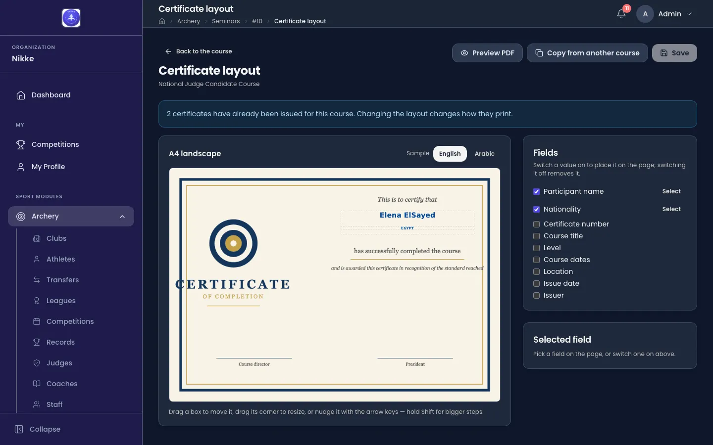 The Certificate layout page in Velos for the National Judge Candidate Course. At the top, a Back to the course link and three buttons: Preview PDF, Copy from another course and Save. A blue notice reads '2 certificates have already been issued for this course. Changing the layout changes how they print.' A card headed A4 landscape, with a Sample switch set to English beside Arabic, shows the course's certificate artwork — cream paper with a navy and gold border, a target emblem and the words CERTIFICATE OF COMPLETION in the left column — and two dashed boxes on it, the first reading Elena ElSayed in bold blue, the second EGYPT, between the artwork's 'This is to certify that' and 'has successfully completed the course'. Under the card: 'Drag a box to move it, drag its corner to resize, or nudge it with the arrow keys — hold Shift for bigger steps.' To the right, a Fields card lists nine checkboxes — Participant name and Nationality ticked with a Select link each, then Certificate number, Course title, Level, Course dates, Location, Issue date and Issuer — and a Selected field card says 'Pick a field on the page, or switch one on above.'
