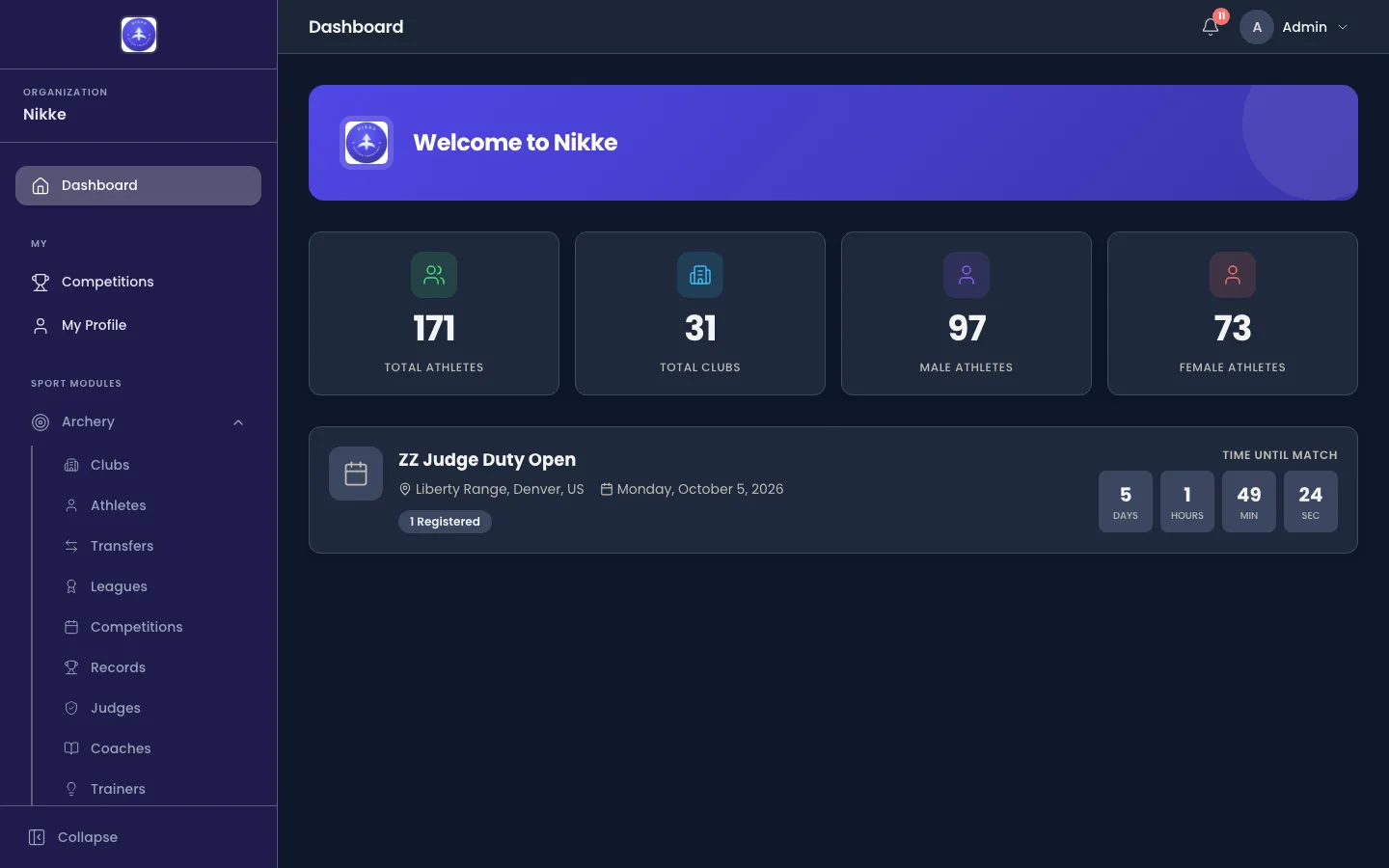 The Velos dashboard: a welcome banner naming your federation, club or academy, four tiles counting total athletes, total clubs, male athletes and female athletes, and a card for the next competition showing its venue, dates, number of registered entries and a countdown.