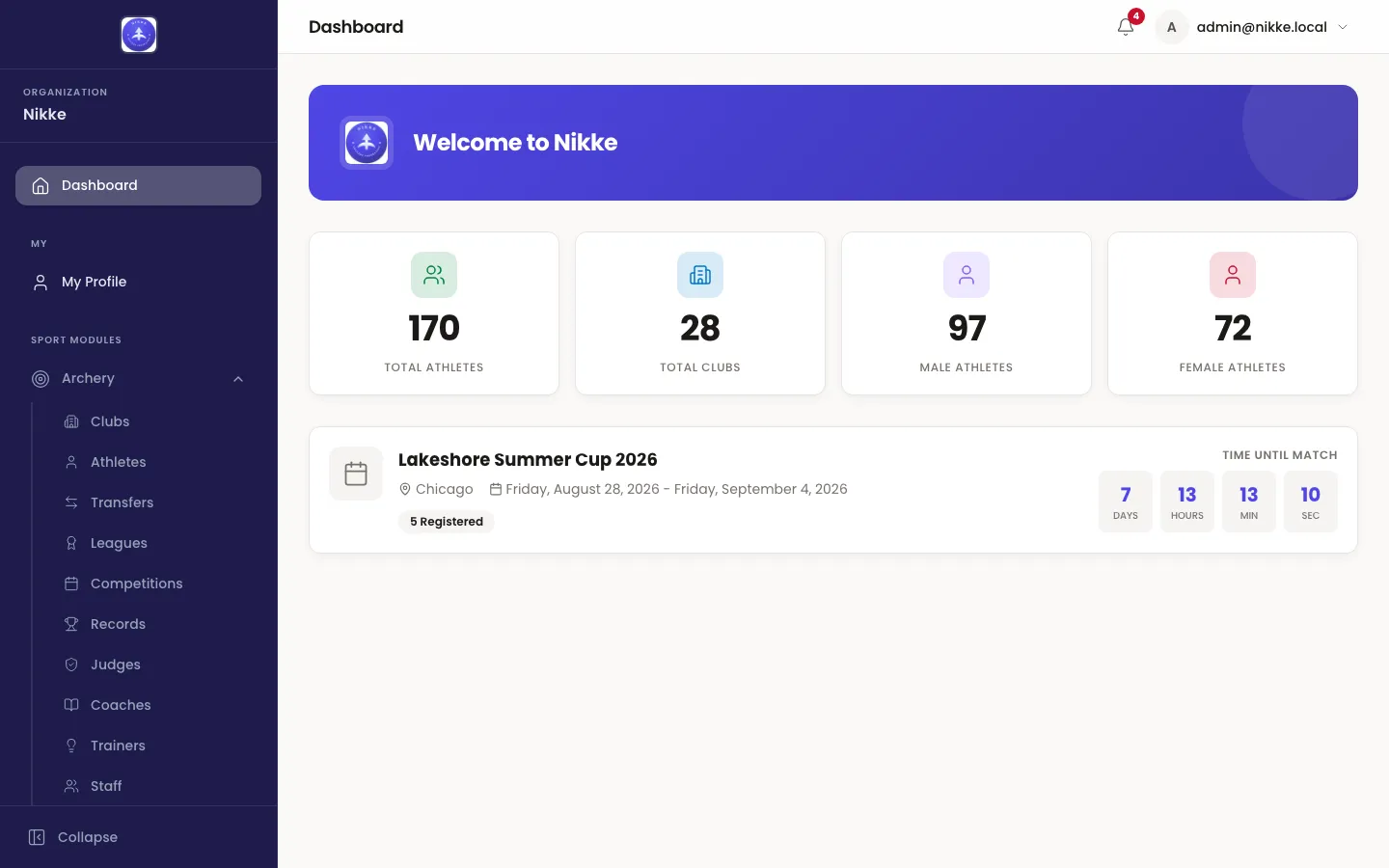 The Velos dashboard: a welcome banner naming your federation, club or academy, four tiles counting total athletes, total clubs, male athletes and female athletes, and a card for the next competition showing its venue, dates, number of registered entries and a countdown.