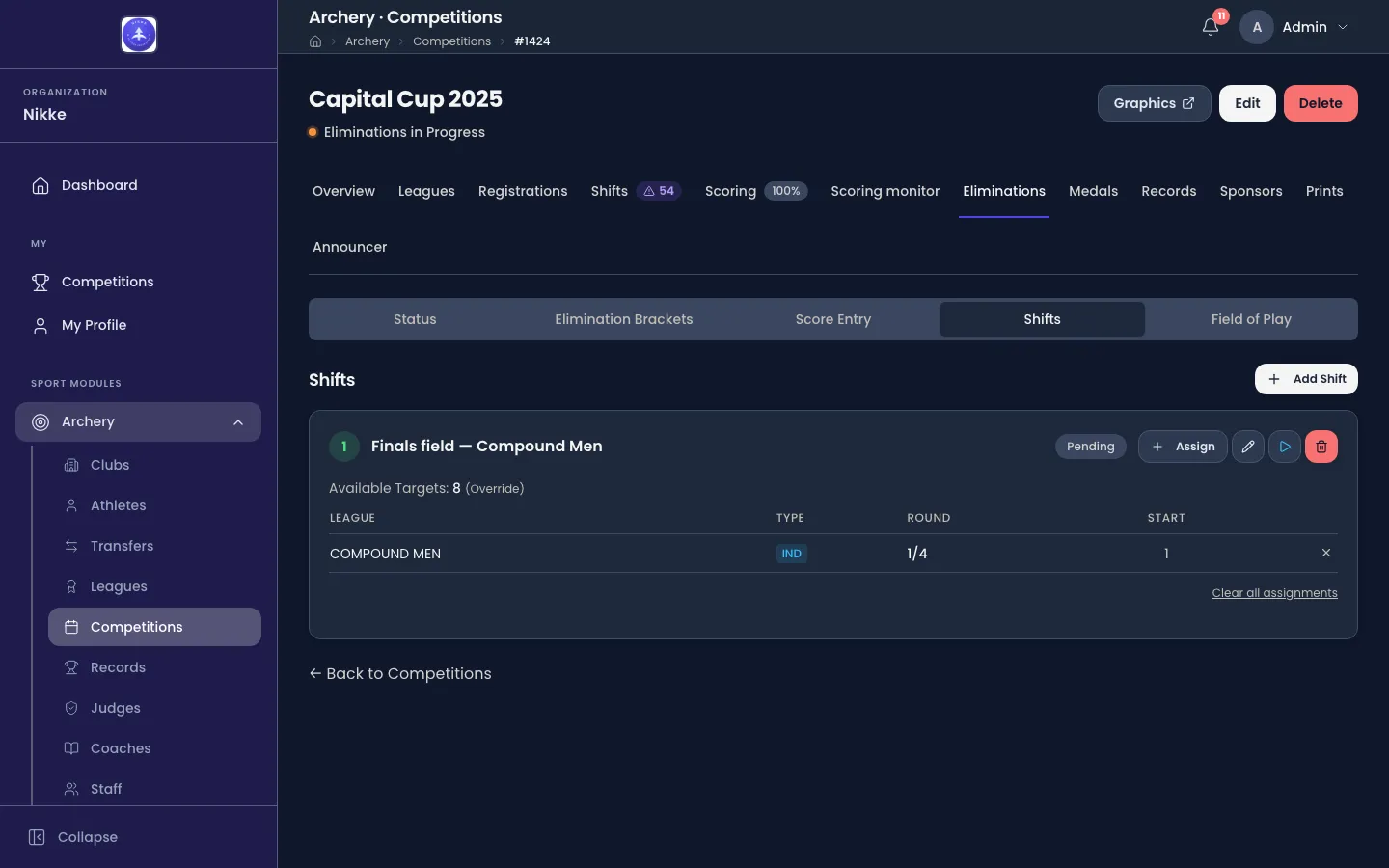 The Shifts view of the Eliminations tab of Capital Cup 2025 in Velos. A row of view buttons reads Status, Elimination Brackets, Score Entry, Shifts and Field of Play, with Shifts chosen. Under a heading Shifts and an + Add Shift button sits one card, numbered 1 and titled Finals field — Compound Men, carrying a Pending badge and Assign, edit, start and delete buttons. A line under it reads Available Targets: 8 (Override), over a table with the columns League, Type, Round and Start holding one row: COMPOUND MEN, tagged IND, round 1/4, start 1. A Clear all assignments link closes the card.